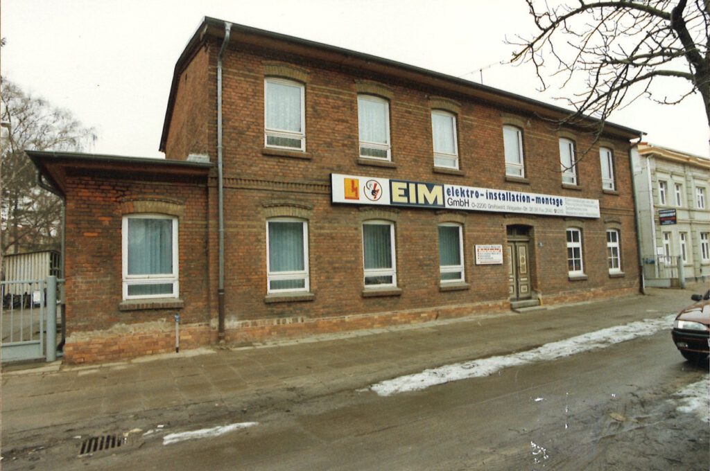Historisches Stammhaus der EIM GmbH an der Wolgaster Straße mit EIM-Schriftzug über dem Eingang